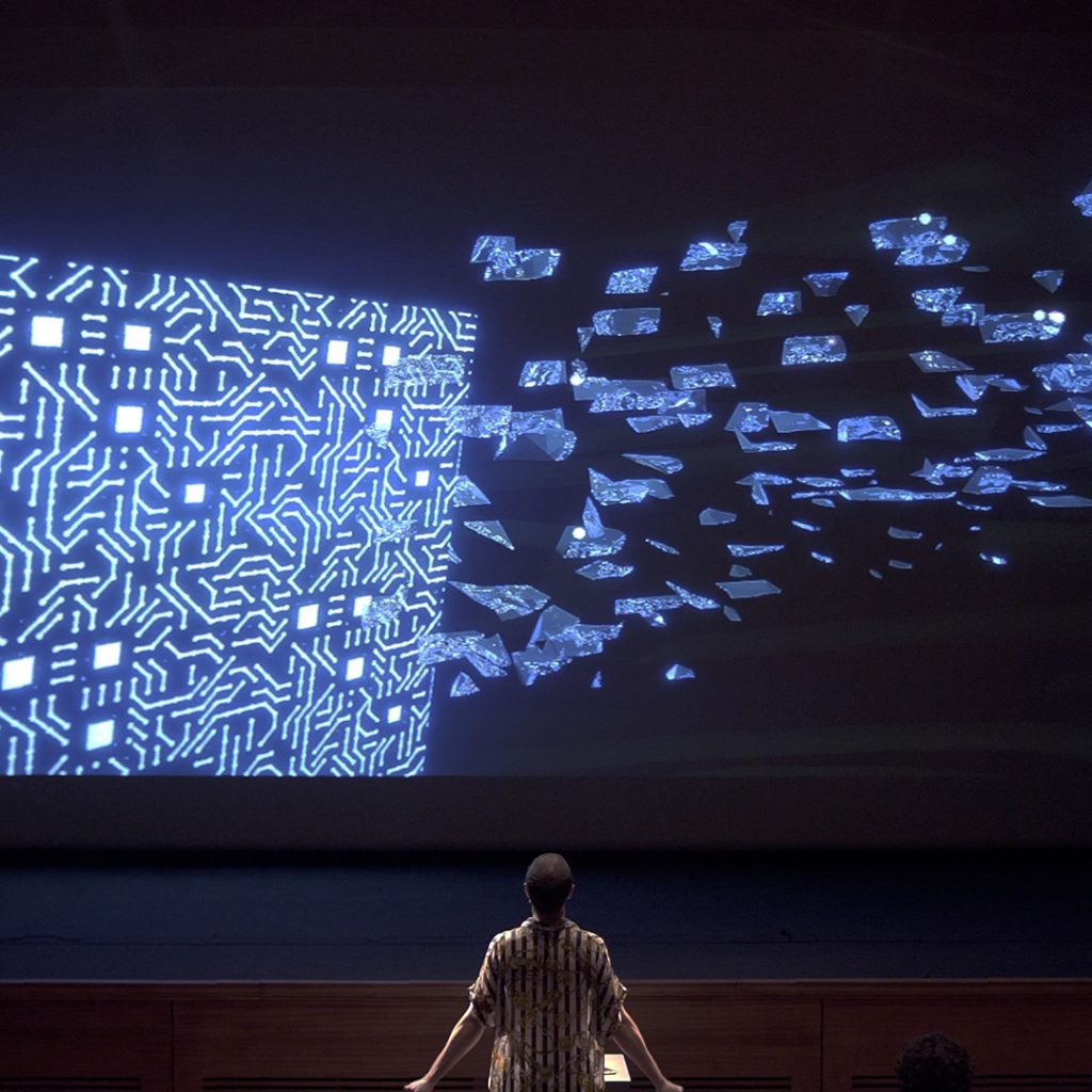 Audience member standing in front of a projection.